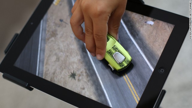 iPads and other tablets have turn renouned gaming platforms, generally among children. Here a child in London plays with an app from Mattel that allows kids to use Hot Wheels cars and other toys to correlate with an iPad.