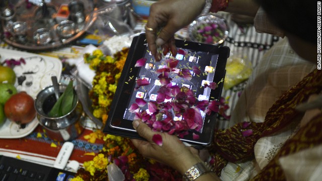 An Indian merchant worships an iPad on Diwali, a Festival of Lights, in New Delhi on Nov 13, 2012. The worshipping of comment books has prolonged been an essential partial of Diwali for a business village in India, and in a pointer of a times some traders are now worshipping electronic gadgets as well. 