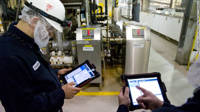 Technician Grimaldo Romero, left, uses his iPad to assistance say machine during a World's Finest Chocolate plant in Chicago, Illinois, on Mar 21, 2013.